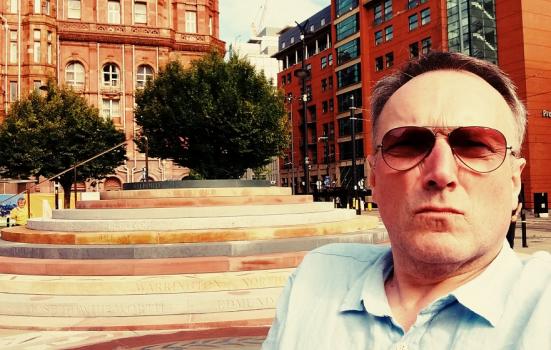photo of Andrew Miller beside Jeremy Miller's Peterloo Memorial in Manchester
