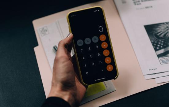 Calculator on phone while person does finance, business, audit and accounts