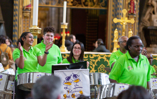 Members of an orchestra play the steel drums at a church