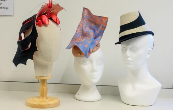 Three hats on display on hat mannequins