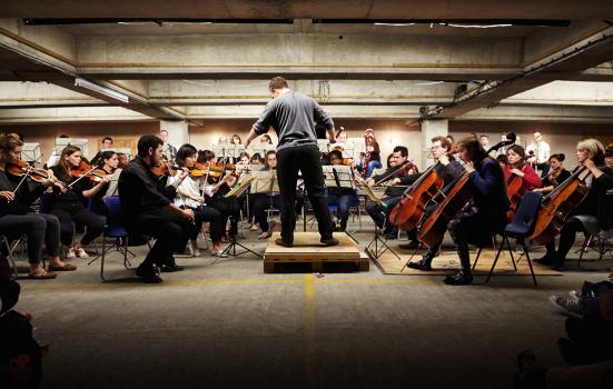 an orchestra performing in a multi-storey car park