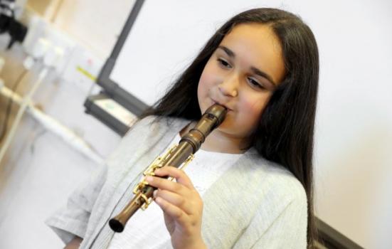 Photo of a girl playing a one-handed recorder
