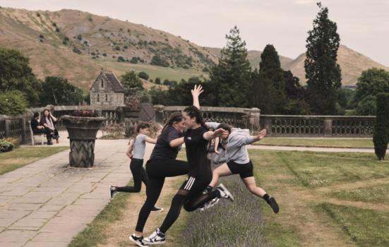 Young people leaping across a lavender bed in Ilam Park