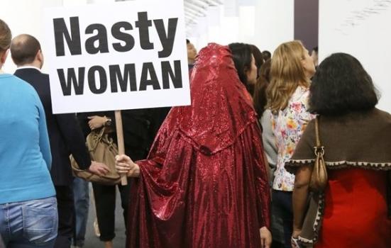 Photo of woman in red shador with banner 'Nasty Woman'