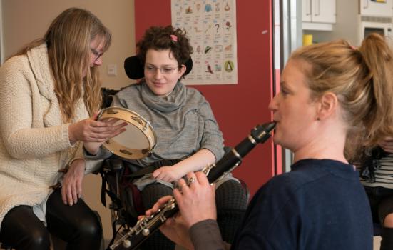 Image of clarinetist & young woman in wheelchair with tambourine
