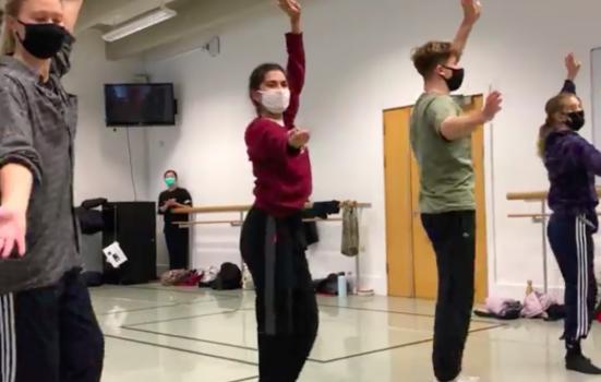 Four students performing dance in a class wearing masks