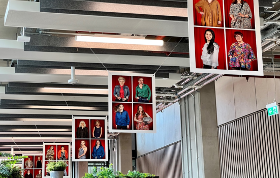Wise Woman exhibition in Leeds School of Arts. The photo depicts five frames hung from the ceiling, each with four portraits of female researchers looking at the camera