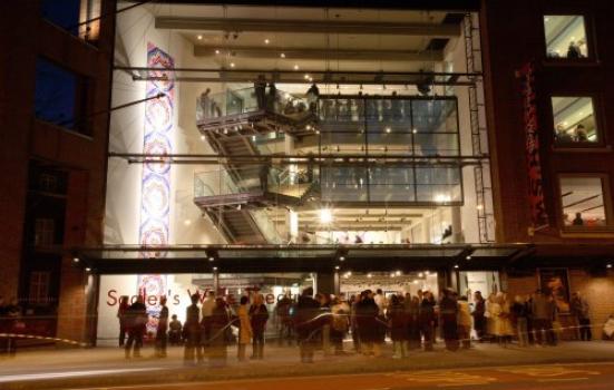 Sadler's Wells building at night with crowd