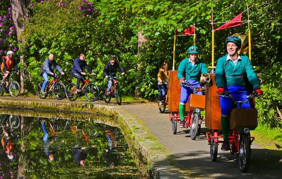 Photo of people cycling along a path by water