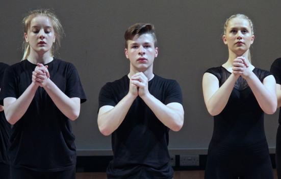 Photograph of dancers with pleading hands