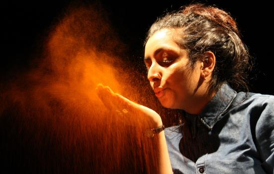 Photo of girl blowing orange powder off hand