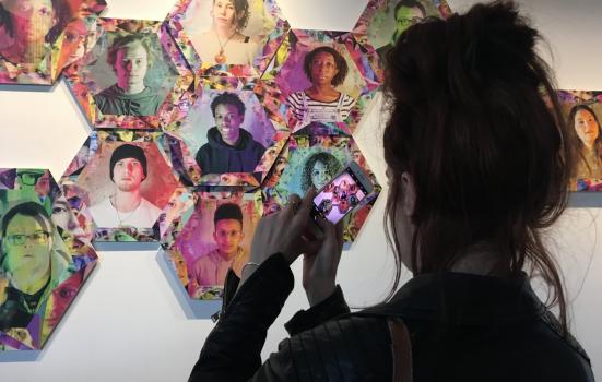 Image of woman taking a picture of collage of headshots