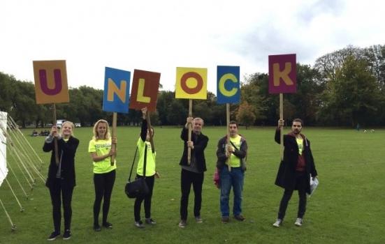 Photo of people holding up letters spelling 'Unlock'
