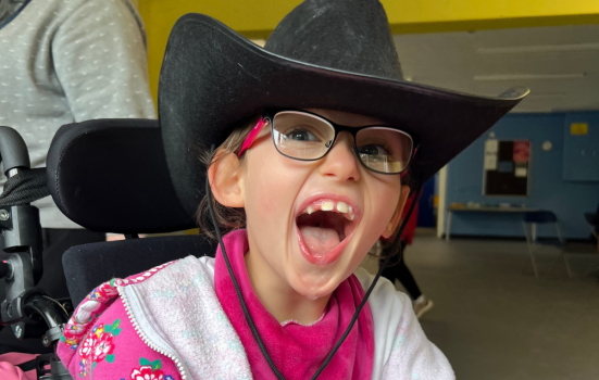 A Keep the Beat participant, she wears a cowboy hat, pink hoodie and glasses