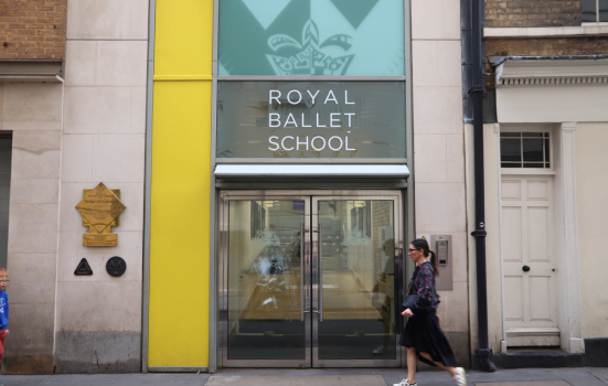 A woman walks past the entrance of the Royal Ballet School in London