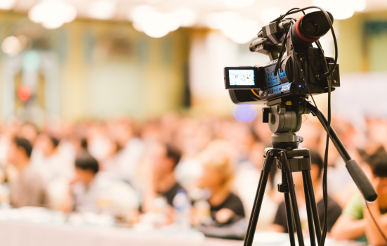 a recording camera films a conference