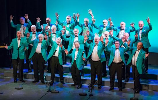 A male voice choir wearing turquoise jackets